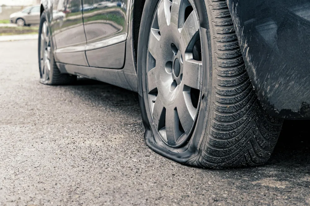 Pneumatico a terra di un'auto parcheggiata